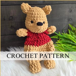 May include: A handmade crochet plush toy resembling a bear with tan yarn, a red shirt, small rounded ears, and a black nose. The text CROCHET PATTERN is displayed in black capital letters across the center of the image over the plush toy.