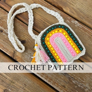 May include: A crocheted rainbow-shaped bag with a white strap and a tassel. The bag is made with a variety of colors, including pink, yellow, green, and brown.