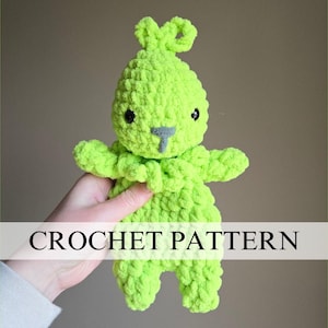 May include: A lime green crochet bunny with black eyes and a gray nose. The handmade stuffed animal has a textured, fuzzy appearance. The text "CROCHET PATTERN" is displayed across the image.