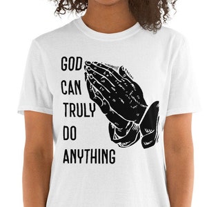 May include: White t-shirt with black text that reads "GOD CAN TRULY DO ANYTHING" and a black illustration of praying hands.
