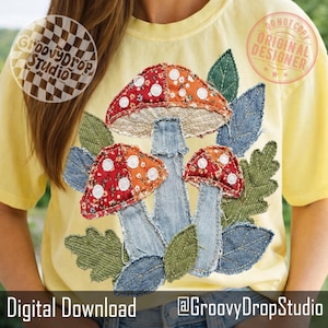 May include: Yellow t-shirt featuring a colorful mushroom design. The mushrooms have red and orange caps with white polka dots, denim stems, and are surrounded by green and denim leaves. The text "Digital Download" and "@GroovyDropStudio" are at the bottom.