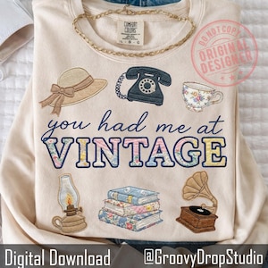 May include: A white ceramic mug with a black handle and the text "But First, Coffee" in a bold, black font. The mug is set against a blurred background, suggesting a cozy setting.