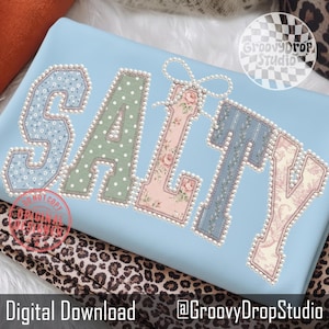 Op de afbeelding: Een lichtblauwe stof met het woord "SALTY" in decoratieve letters. Elke letter heeft een uniek patroon, waaronder bloemen-, stippen- en streepontwerpen, omlijnd met imitatieparels. De tekst "Digital Download" en "@GroovyDropStudio" staat onderaan.