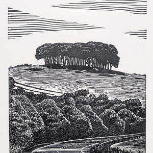 May include: A monochrome woodcut print showing a rural landscape with trees, hills, and a road. The artwork has a detailed depiction of the trees and a textured sky. The title "Nearly There" is printed at the bottom of the print.