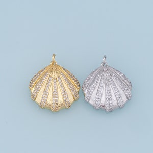 May include: Two shell-shaped pendants with clear crystal embellishments. One pendant is gold-toned and the other is silver-toned.