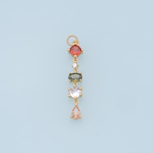 May include: A gold pendant with a chain and five colorful gemstones. The gemstones are red, green, white, and pink.