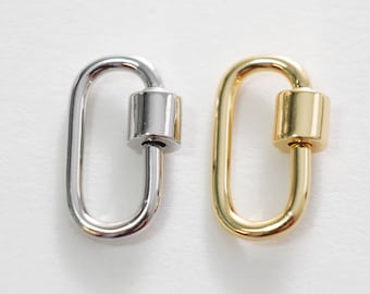 May include: Two oval-shaped metal clasps, one silver and one gold, with a cylindrical barrel in the center. These clasps are used for attaching jewelry or other accessories.