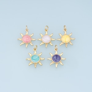 May include: Five gold sun charms with different coloured enamel centres. The colours are pink, white, yellow, turquoise, and purple.