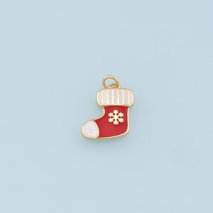 May include: Gold-tone Christmas stocking charm with red and white enamel. The stocking has a white snowflake design.