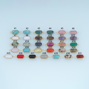 May include: A collection of thirty-one rectangular gemstone connectors, each featuring a faceted stone set in a metal frame with two small loops on the sides. The stones display various colors and patterns, numbered from #1 to #31 for identification.