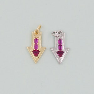 May include: Two arrow charms with pink crystal accents. One charm is gold and the other is silver.