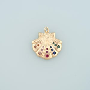 May include: A gold-tone seashell charm with colorful rhinestones. The charm is in the shape of a seashell with a rainbow of rhinestones in the center.