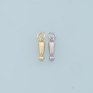 Op de afbeelding: Twee uitroeptekenbedels, een in goud en een in zilver. De bedels zijn klein en hebben een ronde bal aan de onderkant.