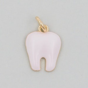 May include: A gold charm in the shape of a tooth with a pink enamel finish.