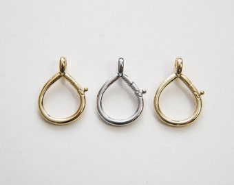 May include: Three teardrop-shaped metal clasps in gold, silver, and bronze.