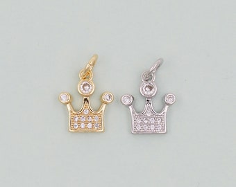 Op de afbeelding: Twee kroonbedels, een in goud en een in zilver, met heldere kristallen accenten. De bedels zijn perfect om een ​​toets van glans toe te voegen aan sieradenprojecten.