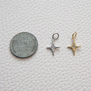 May include: Two silver and gold star charms with a single clear rhinestone in the center of each star.