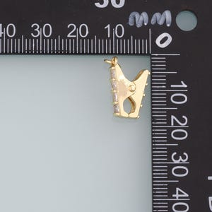 May include: Gold-toned metal clasp with clear crystal accents. The clasp is approximately 1.5 cm in length.