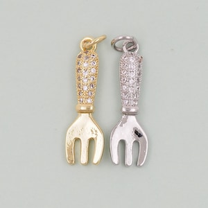 Peut inclure: Deux pendentifs de charme en argent et or en forme de fourchette avec des accents de cristal transparent.