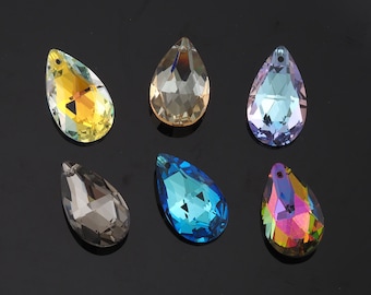 May include: Six teardrop-shaped crystal pendants in various colors, including yellow, clear, blue, and iridescent. Each pendant has a faceted surface and a small hole at the top for stringing. The pendants are displayed against a black background.