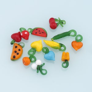 Puede incluir: Una colección de 12 abalorios de frutas y verduras de vidrio de colores. Los abalorios tienen forma de sandía, fresa, cereza, zanahoria, maíz, corazón, limón y racimo de uvas. Los abalorios son perfectos para añadir un toque de fantasía a las joyas, los llaveros u otras manualidades.