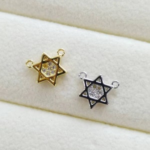 May include: Two gold and silver Star of David charms with clear crystal accents. The charms have two jump rings for attaching to a necklace or bracelet.