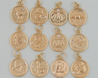 May include: Twelve gold zodiac charms, each featuring a single rhinestone. The charms are arranged in a grid pattern on a light beige background.