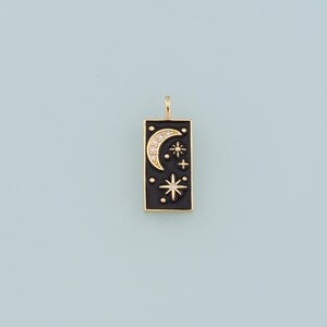 May include: Gold charm with a black enamel rectangle featuring a crescent moon and stars with clear rhinestones.