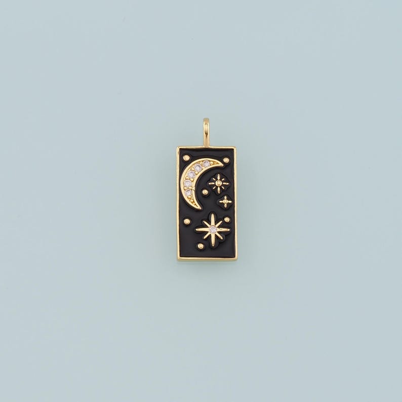 May include: Gold charm with a black enamel rectangle featuring a crescent moon and stars with clear rhinestones.