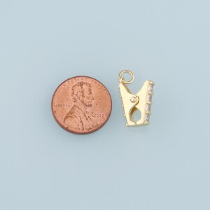 May include: Gold-toned clasp with clear crystal accents. The clasp is about the size of a US penny.