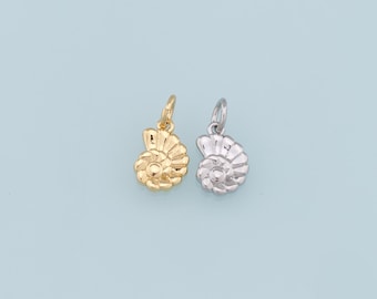 May include: Two shell-shaped charms, one gold and one silver, with a detailed design. The charms are perfect for adding a touch of nautical style to jewelry.