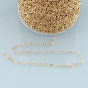 May include: A spool of gold heart-shaped chain. The chain is made of metal and is approximately 1 mm in width.