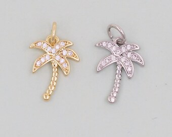 May include: Two palm tree charms, one gold and one silver, with clear crystal accents.