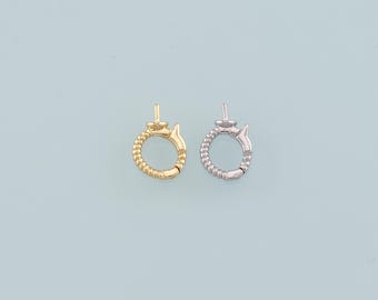 May include: Two metal jewelry clasps. One is gold-colored, the other is silver-colored. Both clasps have a circular design with a textured beaded pattern and a small decorative element on top. The clasps are set against a light blue background.