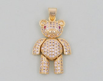 May include: Gold-coloured teddy bear pendant, encrusted with clear and pink gemstones. The bear has red gemstone eyes and a bail for a necklace chain. A charming piece of jewellery.
