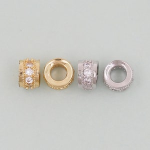 May include: Three metal spacer beads with clear crystal accents. The beads are gold, silver, and a combination of gold and silver.