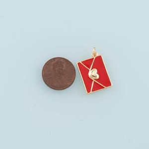 May include: Gold-tone charm shaped like a red envelope with a gold heart on the front.