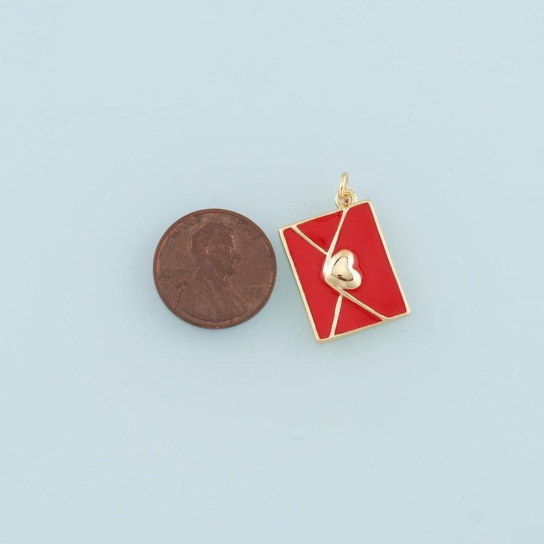 May include: Gold-tone charm shaped like a red envelope with a gold heart on the front.