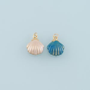 May include: Two gold-tone shell charms, one with a white and pink shell and the other with a blue shell.