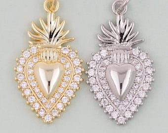 May include: Two gold and silver heart-shaped charms with a crown and flame design. The charms are adorned with clear rhinestones.