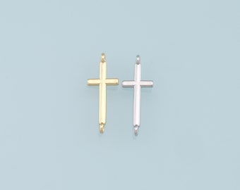 May include: Two metal cross charms, one gold and one silver, with a loop at the top for attaching to a necklace or bracelet.