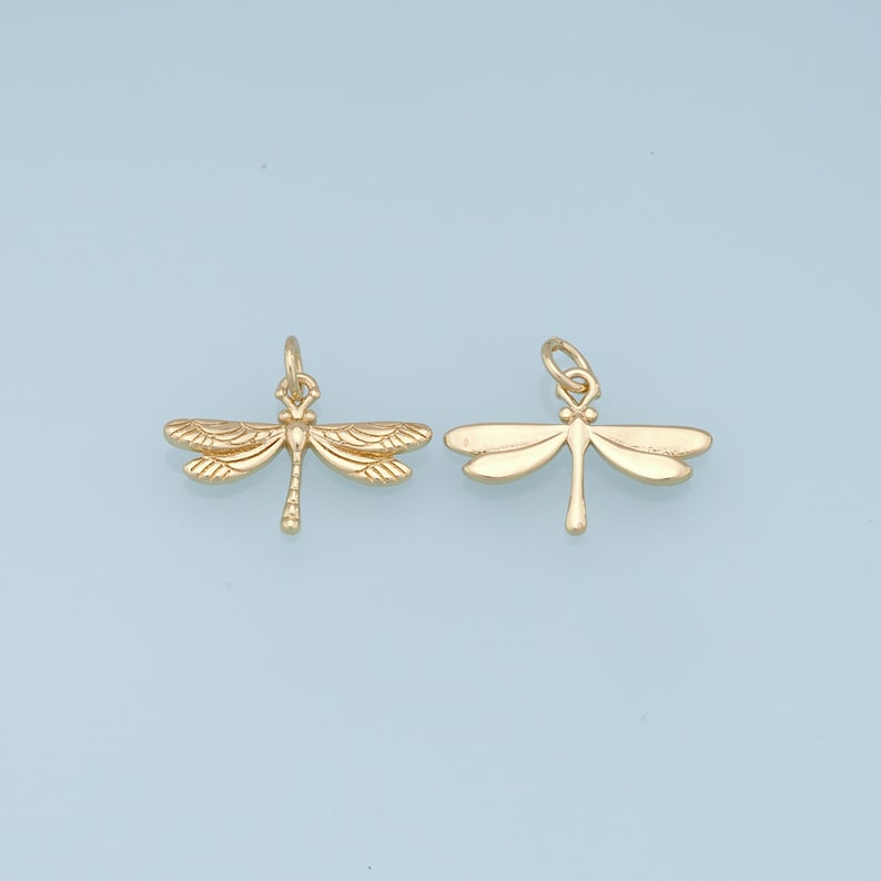 May include: Two gold-colored dragonfly charms with detailed wings and a loop for attaching to jewelry.