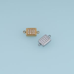 May include: Two rectangular jewelry connectors, one gold-toned and one silver-toned, each featuring a grid of small clear embedded stones and two small circular loops on opposite ends for attaching chains or other jewelry components.