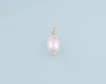 May include: A white pearl pendant with a gold loop and a gold bead at the bottom.