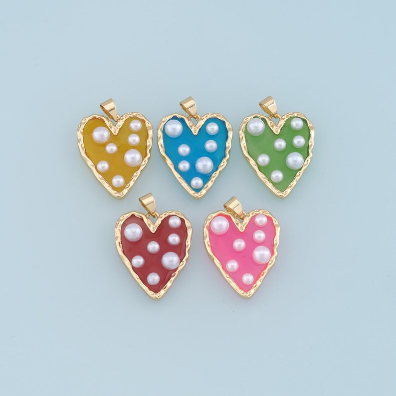 May include: Five gold heart-shaped pendants with different colored enamel and white pearl accents.