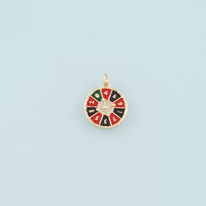 May include: Gold-tone charm with a red, black, and green roulette wheel design. The wheel has numbers 0, 1, 2, 3, 4, 5, 6, 7, 8, 9, 10, 11, 12, 13, 14, 15, 16, 17, 18, 19, 20, 21, 22, 23, 24, 25, 26, 27, 28, 29, 30, 31, 32, 33, 34, 35, 36.