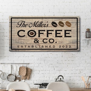 May include: A rustic wooden sign with the text "The Miller's Coffee & Co. Established 2022" in black lettering. Three coffee beans are depicted above the text.