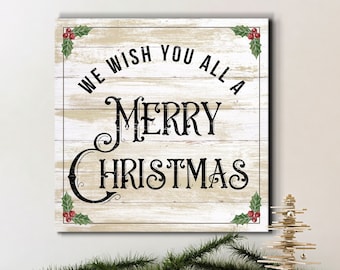 May include: A whitewashed wood sign with a rustic, distressed look. The sign has a black border and says "We wish you all a Merry Christmas" with red holly berries in the corners.