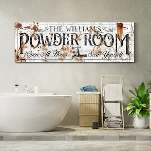 May include: Rustic white metal sign with brown rust accents. The sign reads "The Williams' Powder Room Open All Hours Seat Yourself".