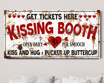 May include: A rectangular metal sign with the words "GET TICKETS HERE" and "KISSING BOOTH" in red and black lettering. The sign has a distressed, rusty appearance with heart accents and the text "OPEN DAILY 5¢ PER SMOOCH".